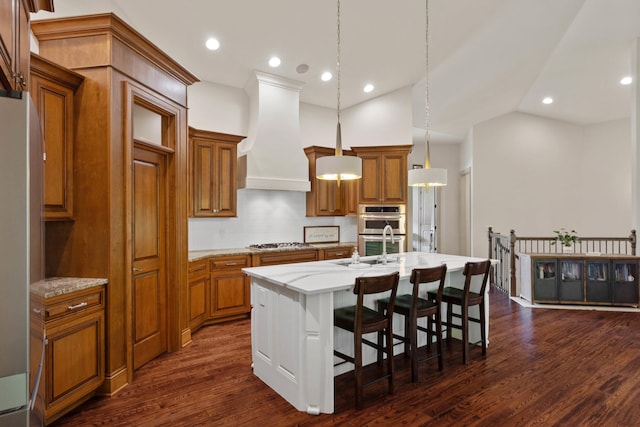 5809 Morning Star Ct, Columbia, MO 65203 - kitchen with appliances with stainless steel finishes, brown cabinetry, custom range hood, a kitchen island with sink, and backsplash