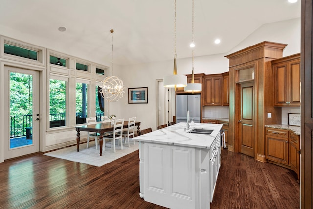 5809 Morning Star Ct, Columbia, MO 65203 - kitchen featuring freestanding refrigerator, a chandelier, brown cabinets, a kitchen island with sink, and dark wood-type flooring