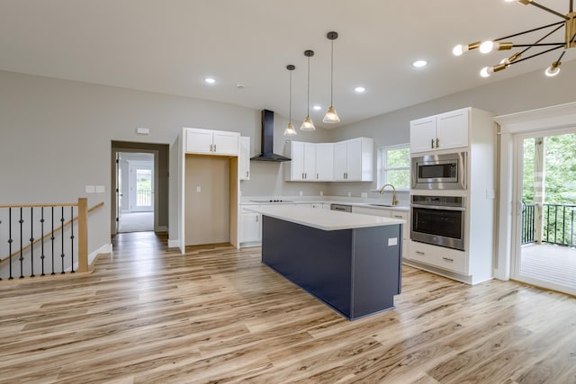 4305 Peregrine Pl, Columbia, MO 65202 - kitchen featuring appliances with stainless steel finishes, wall chimney exhaust hood, light wood-style floors, a center island, and recessed lighting
