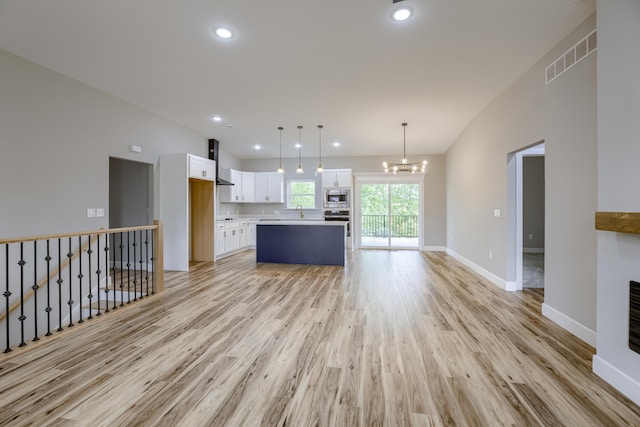 4305 Peregrine Pl, Columbia, MO 65202 - unfurnished living room with light wood finished floors, a chandelier, recessed lighting, and vaulted ceiling