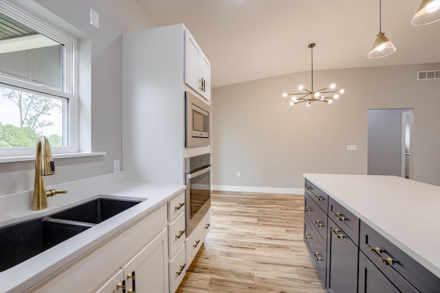 4305 Peregrine Pl, Columbia, MO 65202 - kitchen featuring appliances with stainless steel finishes, light wood-style flooring, a chandelier, decorative light fixtures, and light countertops