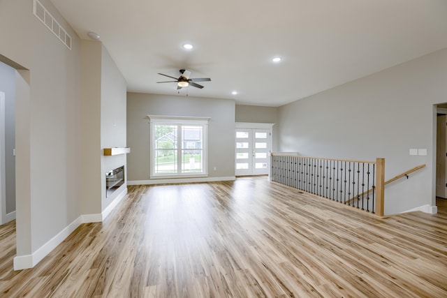 4305 Peregrine Pl, Columbia, MO 65202 - unfurnished living room featuring ceiling fan, light wood-style flooring, a glass covered fireplace, french doors, and recessed lighting