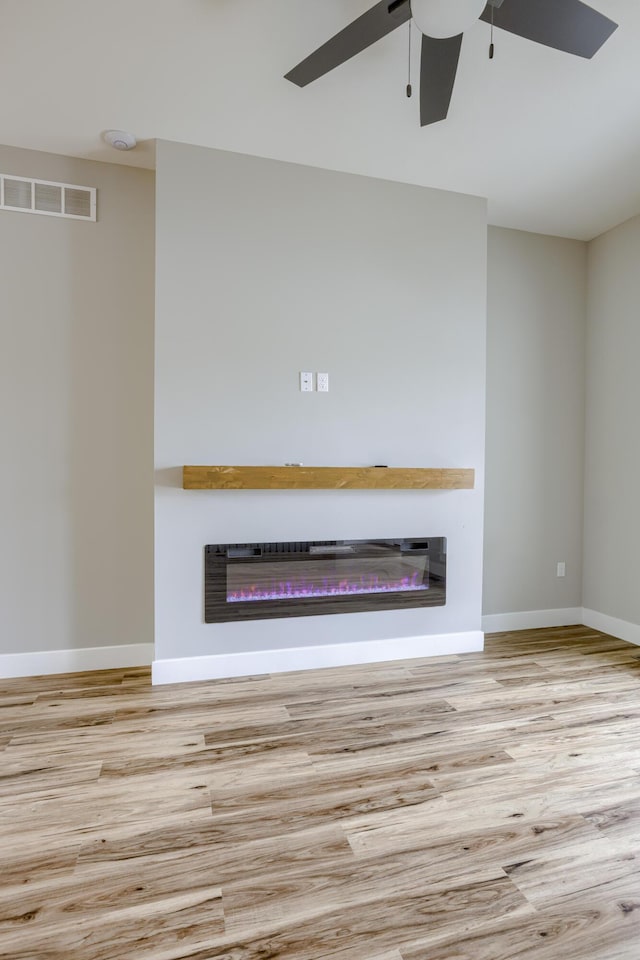 4305 Peregrine Pl, Columbia, MO 65202 - unfurnished living room with a glass covered fireplace, wood finished floors, and ceiling fan