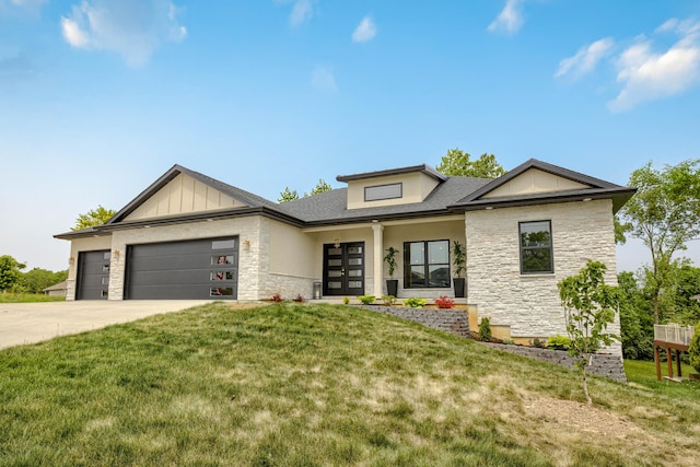 4305 Peregrine Pl, Columbia, MO 65202 - view of front of property featuring stone siding, a garage, a front yard, driveway, and french doors