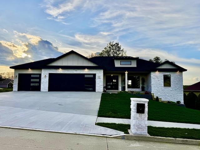 4305 Peregrine Pl, Columbia, MO 65202 - view of front facade with stone siding, a front yard, a garage, driveway, and board and batten siding