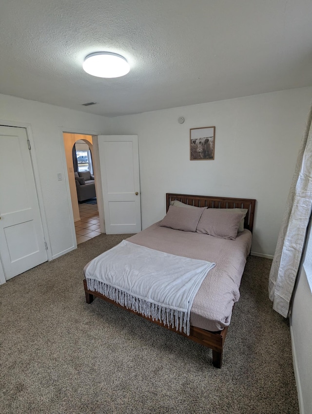 505 W Worley St, Columbia, MO 65203 - carpeted bedroom with a textured ceiling and arched walkways
