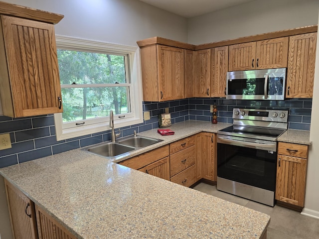 3109 Appalachian Dr, Columbia, MO 65203 - kitchen with stainless steel appliances, backsplash, light countertops, and brown cabinetry