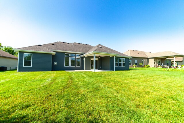 1915 Muirfield Dr, Columbia, MO 65203 - back of property with a patio area, ceiling fan, and a lawn