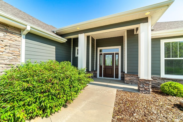 1915 Muirfield Dr, Columbia, MO 65203 - view of exterior entry with stone siding, roof with shingles, and covered porch