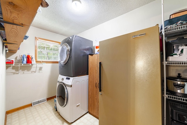 6002 E Molly Ln, Columbia, MO 65202 - laundry area with estacked washer and dryer, light floors, and a textured ceiling