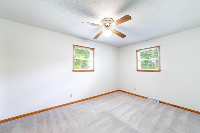 6002 E Molly Ln, Columbia, MO 65202 - empty room featuring healthy amount of natural light, a ceiling fan, light carpet, and a textured ceiling