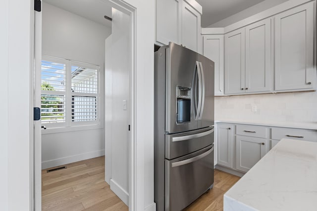 605 Angels Rest Way, Columbia, MO 65203 - kitchen with stainless steel fridge with ice dispenser, light wood-style floors, light stone counters, and decorative backsplash