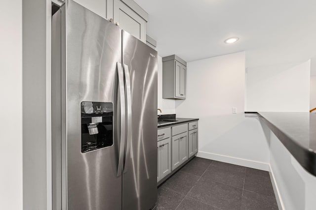 605 Angels Rest Way, Columbia, MO 65203 - kitchen with stainless steel fridge with ice dispenser, gray cabinetry, dark tile patterned floors, and dark countertops