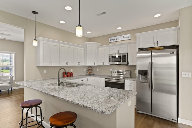 15409 Allegiance Ave, Ashland, MO 65010 - kitchen featuring appliances with stainless steel finishes, white cabinetry, dark wood-type flooring, a kitchen bar, and recessed lighting