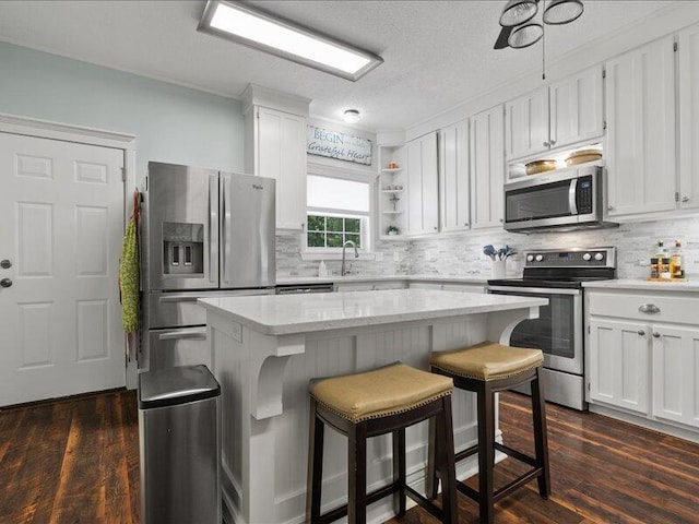 205 Johnson Ct, Ashland, MO 65010 - kitchen featuring stainless steel appliances, open shelves, white cabinetry, decorative backsplash, and a kitchen island