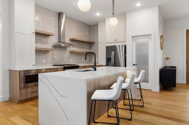 5413 Briar Rose Ct, Columbia, MO 65203 - kitchen featuring appliances with stainless steel finishes, modern cabinets, wall chimney range hood, open shelves, and a breakfast bar area