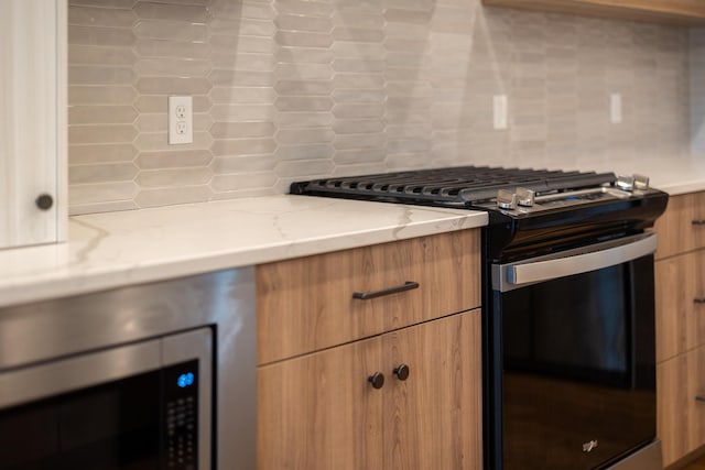 5413 Briar Rose Ct, Columbia, MO 65203 - kitchen with stainless steel appliances, decorative backsplash, brown cabinetry, light stone countertops, and modern cabinets