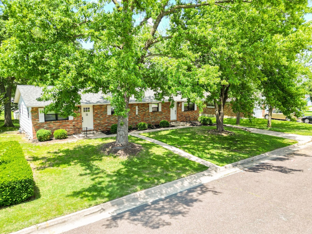 3405 Balboa Ln Unit A-B, Columbia, MO 65203 - obstructed view of property featuring brick siding, a front yard, and roof with shingles