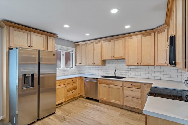 522 Huntridge Dr, Columbia, MO 65201 - kitchen with appliances with stainless steel finishes, light brown cabinetry, tasteful backsplash, light countertops, and light wood finished floors