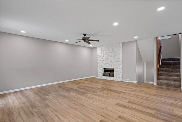 522 Huntridge Dr, Columbia, MO 65201 - unfurnished living room featuring ceiling fan, stairs, light wood finished floors, recessed lighting, and a stone fireplace