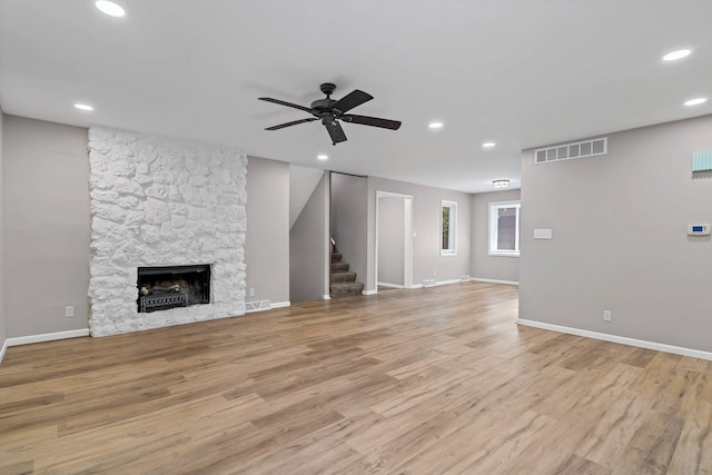 522 Huntridge Dr, Columbia, MO 65201 - unfurnished living room featuring ceiling fan, recessed lighting, stairway, wood finished floors, and a stone fireplace