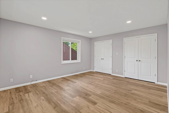 522 Huntridge Dr, Columbia, MO 65201 - unfurnished bedroom with multiple closets, light wood-type flooring, and recessed lighting