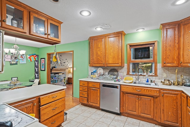 2808 Pine Dr, Columbia, MO 65202 - kitchen featuring stainless steel dishwasher, backsplash, light countertops, brown cabinets, and a chandelier