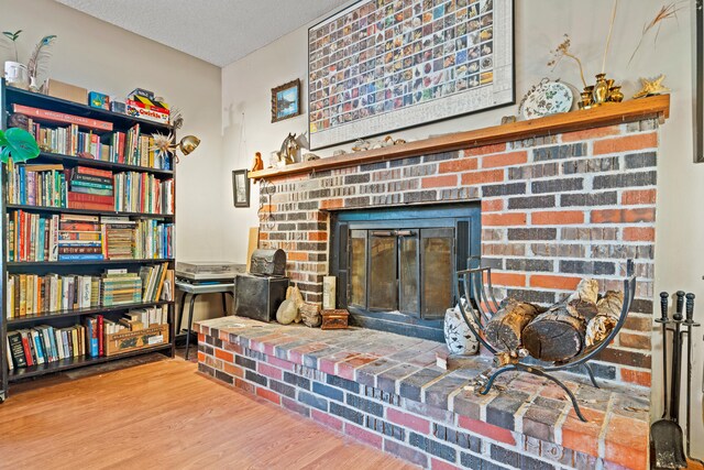 2808 Pine Dr, Columbia, MO 65202 - living area featuring a brick fireplace, wood finished floors, and a textured ceiling