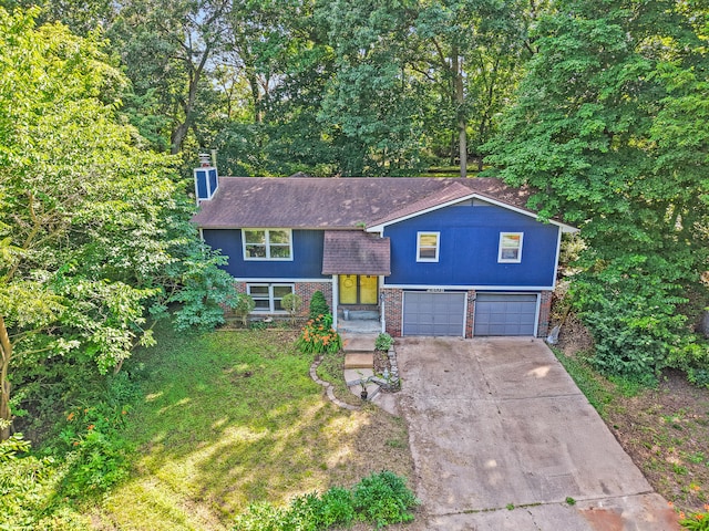 2808 Pine Dr, Columbia, MO 65202 - view of front facade with concrete driveway, brick siding, a garage, a front yard, and a chimney