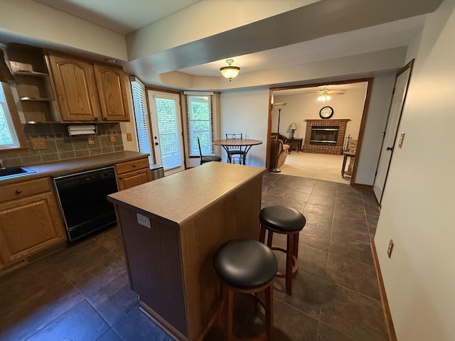 4413 Shoram Ct, Columbia, MO 65203 - kitchen with black dishwasher, a breakfast bar area, healthy amount of natural light, and dark tile patterned flooring