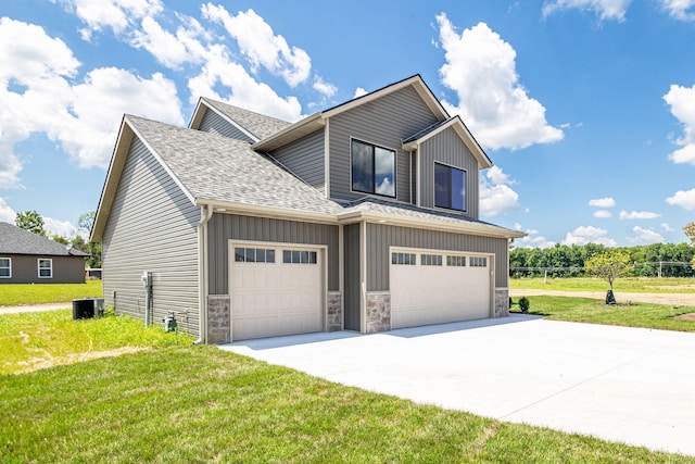 3321 Gray Birch Dr, Columbia, MO 65202 - view of side of home with board and batten siding, roof with shingles, concrete driveway, a lawn, and stone siding