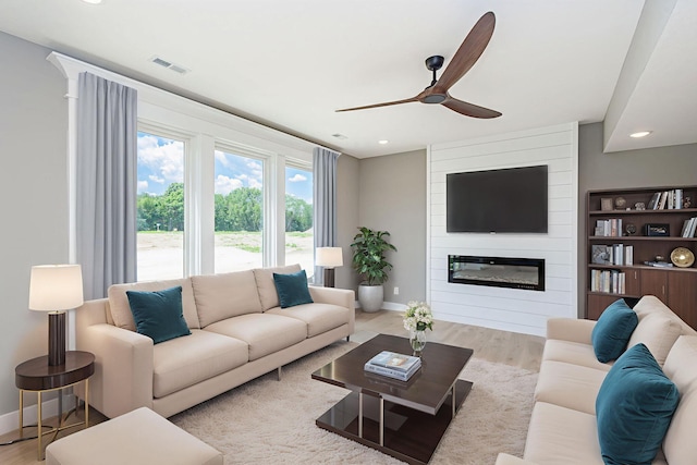 3321 Gray Birch Dr, Columbia, MO 65202 - living room featuring a large fireplace, a ceiling fan, wood finished floors, and recessed lighting