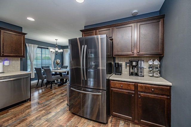 5808 Islip Dr, Columbia, MO 65201 - kitchen with stainless steel appliances, dark brown cabinets, backsplash, dark wood finished floors, and a chandelier