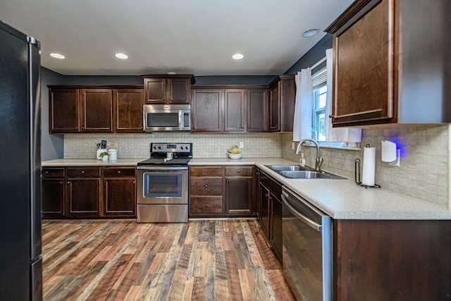 5808 Islip Dr, Columbia, MO 65201 - kitchen with appliances with stainless steel finishes, wood-type flooring, dark brown cabinetry, light countertops, and decorative backsplash