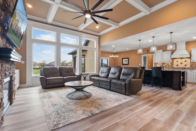 6406 Crooked Switch Ct, Columbia, MO 65201 - living room featuring coffered ceiling, a ceiling fan, beam ceiling, a stone fireplace, and light wood-type flooring