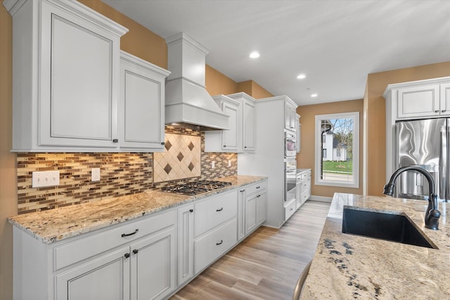 6406 Crooked Switch Ct, Columbia, MO 65201 - kitchen featuring appliances with stainless steel finishes, custom range hood, light wood-style flooring, decorative backsplash, and recessed lighting