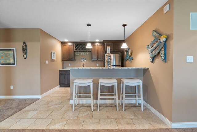 6406 Crooked Switch Ct, Columbia, MO 65201 - kitchen with a kitchen breakfast bar, stainless steel fridge, hanging light fixtures, a peninsula, and dark brown cabinetry
