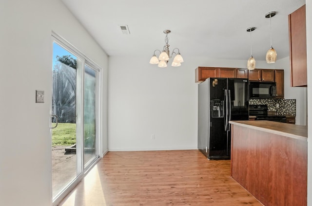 3904 Clydesdale Dr, Columbia, MO 65202 - kitchen featuring black appliances, light wood-style floors, a chandelier, pendant lighting, and tasteful backsplash