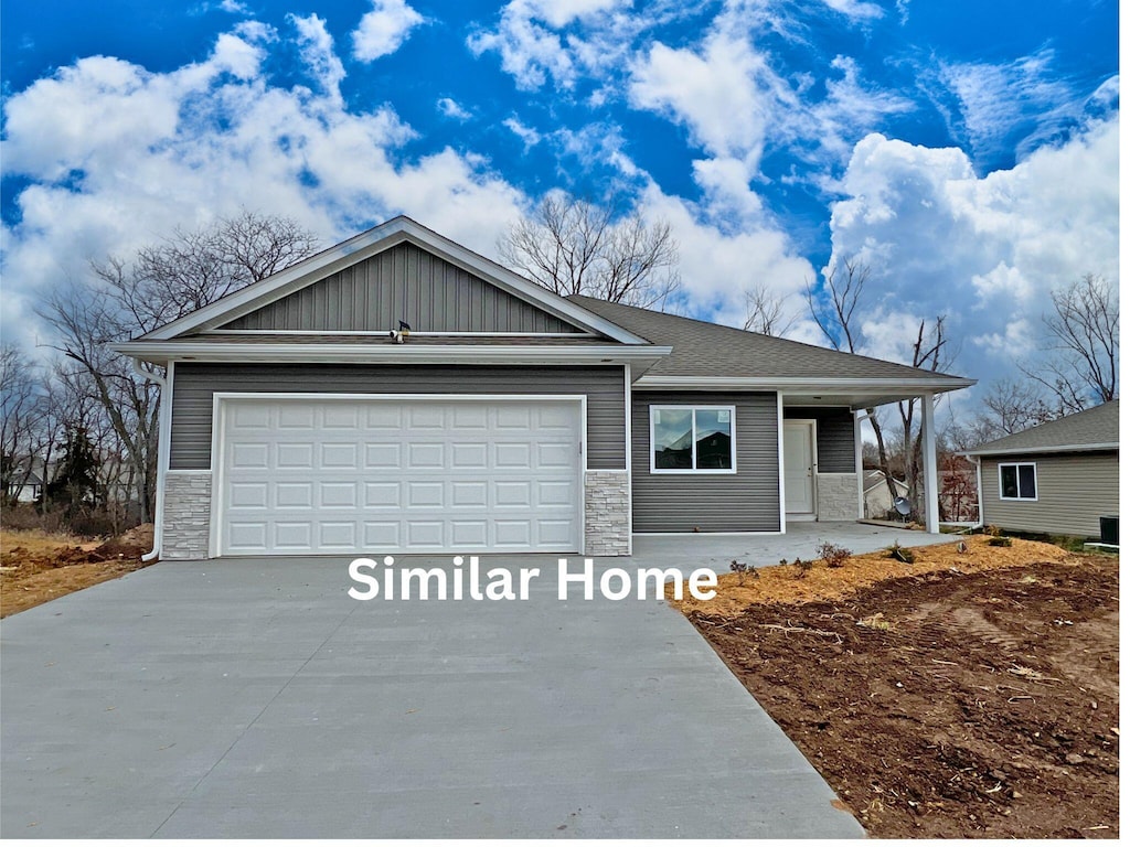 7809 N Brookhill Dr, Columbia, MO 65202 - ranch-style home with driveway, stone siding, an attached garage, and covered porch