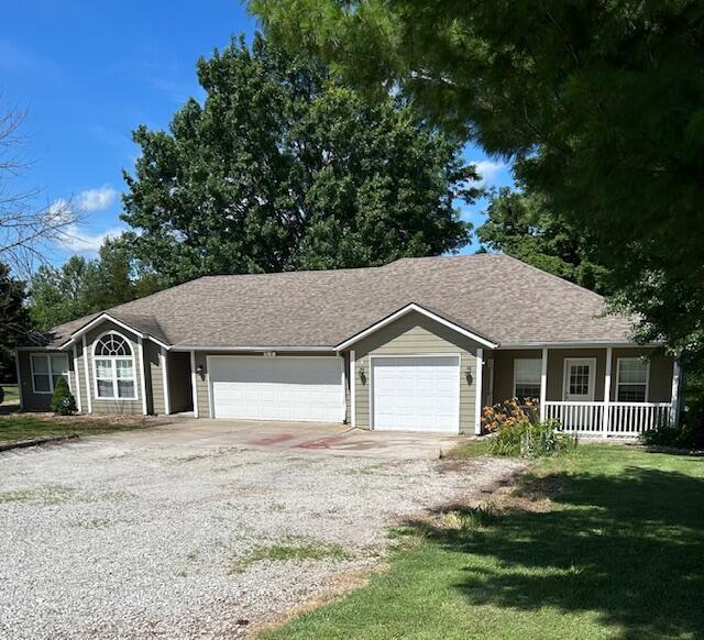 9855 N Route E, Harrisburg, MO 65256 - single story home with driveway, a garage, covered porch, and a front lawn