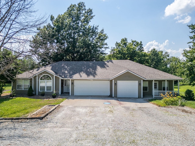 9855 N Route E, Harrisburg, MO 65256 - ranch-style house with driveway, covered porch, an attached garage, a front yard, and a shingled roof