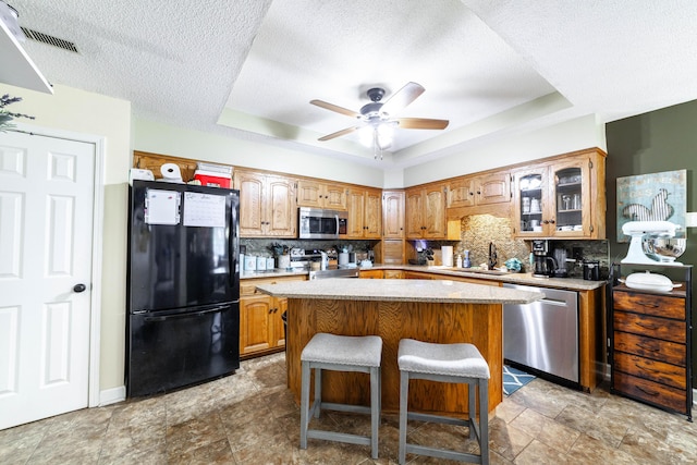 605 Teakwood Ct, Ashland, MO 65010 - kitchen with appliances with stainless steel finishes, a raised ceiling, backsplash, light countertops, and glass insert cabinets