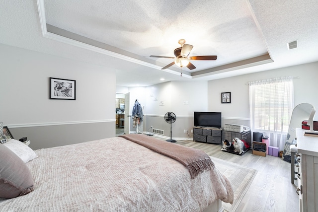605 Teakwood Ct, Ashland, MO 65010 - bedroom featuring a tray ceiling, light wood-style floors, a textured ceiling, and a ceiling fan