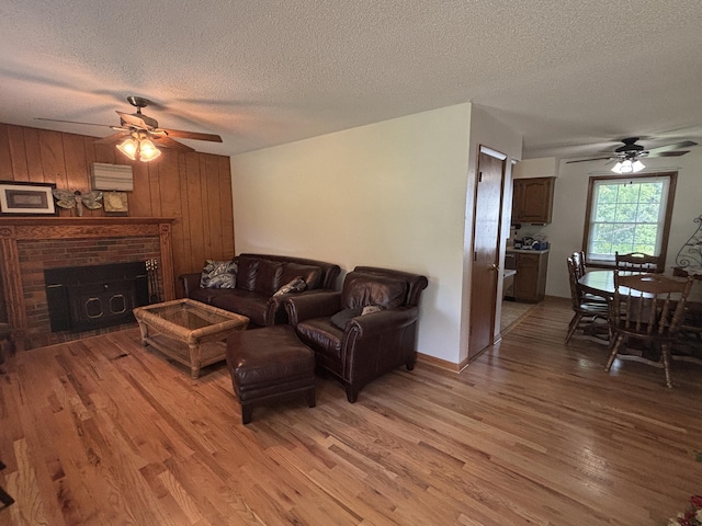 14200 N Yy, Columbia, MO 65202 - living area featuring a ceiling fan, light wood-style flooring, a fireplace, and a textured ceiling