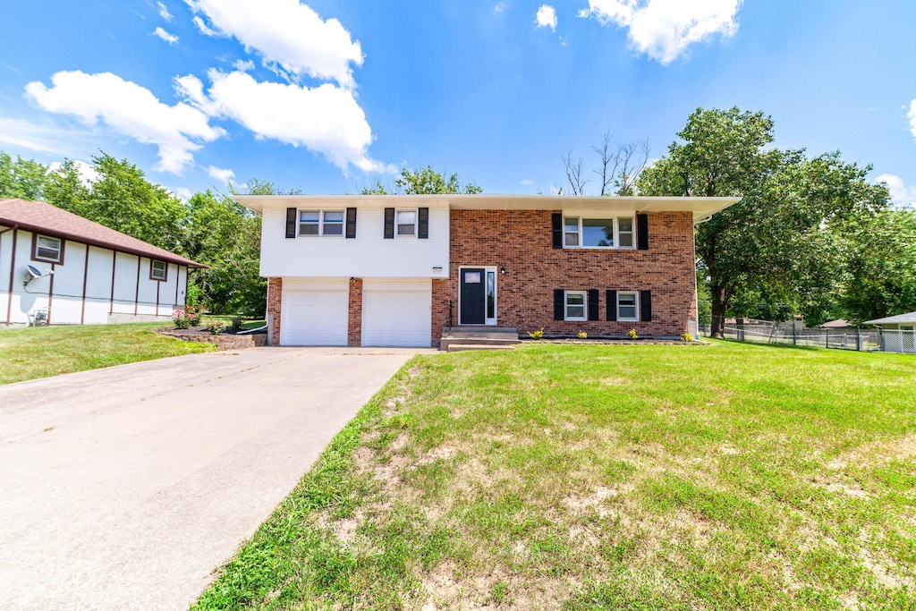 2520 N Lake Of The Woods Rd, Columbia, MO 65202 - split foyer home featuring an attached garage, brick siding, and concrete driveway
