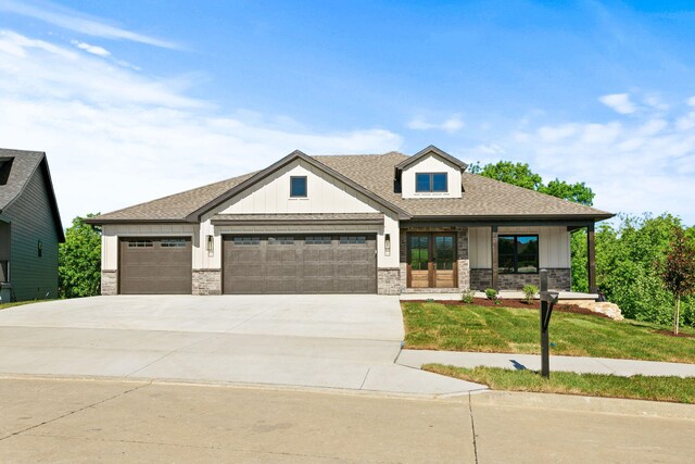 924 Engle Dr, Columbia, MO 65203 - view of front of property with a garage, board and batten siding, driveway, a shingled roof, and stone siding
