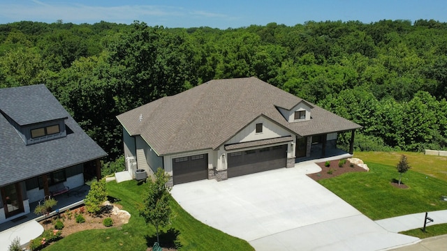 924 Engle Dr, Columbia, MO 65203 - view of front of house featuring an attached garage, a forest view, driveway, and a front lawn