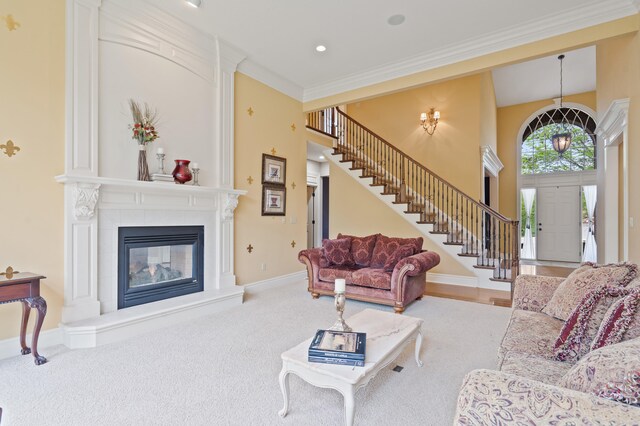 4902 Cochero Ct, Columbia, MO 65203 - carpeted living room featuring stairs, a fireplace, ornamental molding, a towering ceiling, and recessed lighting