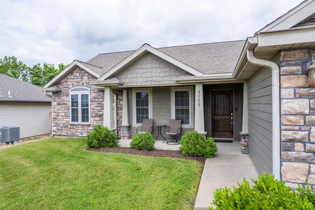 3509 Tuscany, Columbia, MO 65202 - doorway to property featuring a lawn, covered porch, stone siding, and a shingled roof