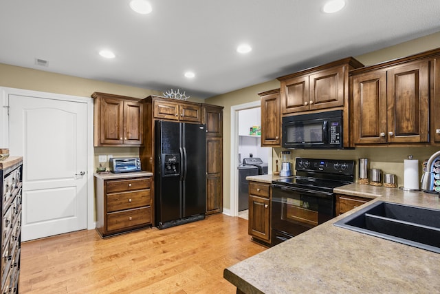 3509 Tuscany, Columbia, MO 65202 - kitchen featuring black appliances, light wood-style flooring, recessed lighting, washing machine and dryer, and light countertops